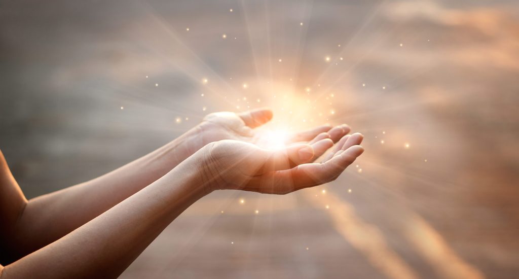 Woman hands praying for blessing from god on sunset background